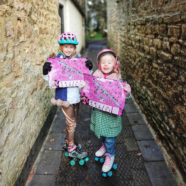 Two girls on roller skates with maps